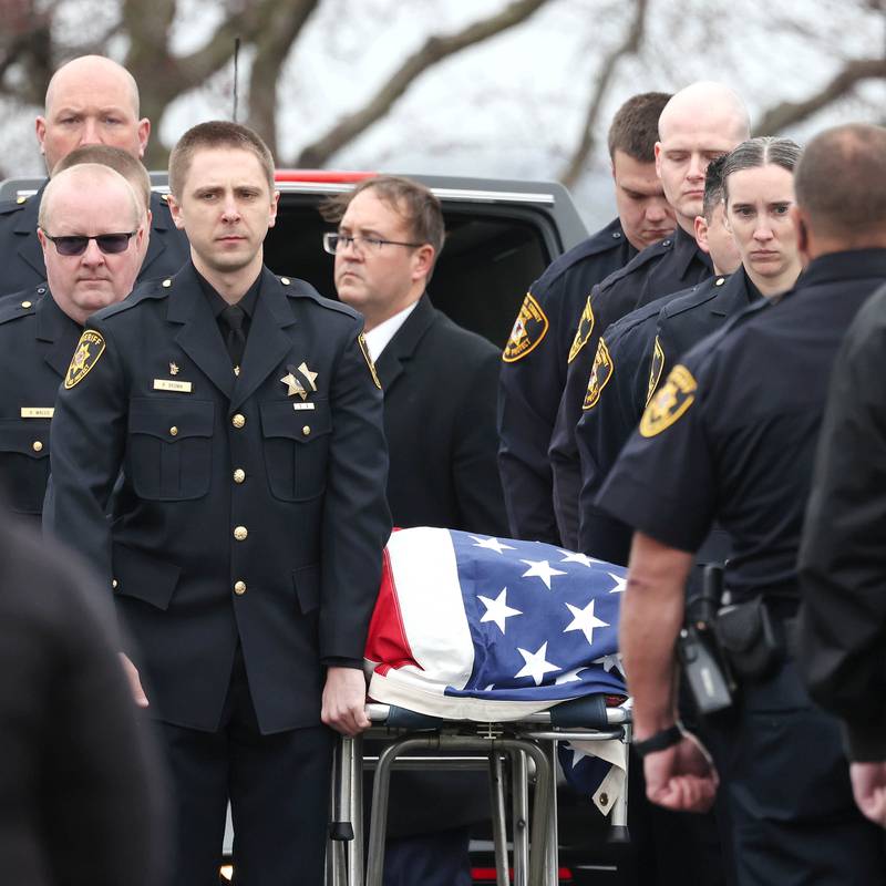 DeKalb County Sheriff’s Deputies remove the flag-draped gurney carrying the body of DeKalb County Sheriff’s Deputy Christina Musil from the Hearse Monday, April 1, 2024, at Butala Funeral Home following the processional honoring the fallen officer. Musil, 35, was killed Thursday while on duty after a truck rear-ended her police vehicle in Waterman.