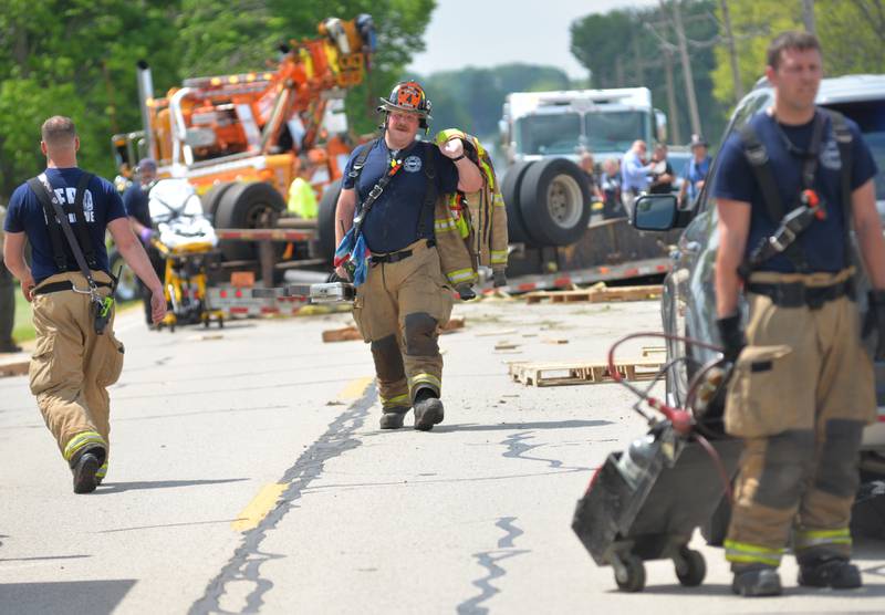 Byron firefighters with the heavy rescue unit walk back from the overturned  semi-tractor and trailer on Pines Road, just west of Oregon. The accident forced the closure of a portion of the road from the city limits, west to Gale Road. The accident remains under investigation.