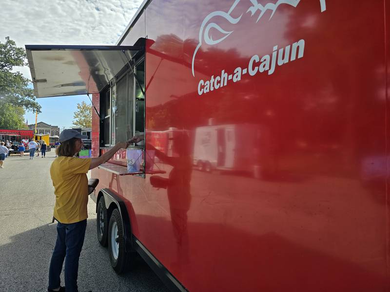 Catch-a-Cajun serves a customer Saturday, Sept. 14, 2024, during the Fall Food Truck Festival in Streator's City Park.