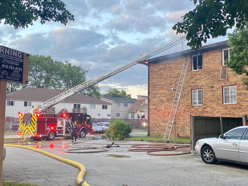 A Rochelle Fire Department ladder truck deploys its crews as firefighters work to get a blaze under control in the rear parking lot of a Husky Ridge apartment complex in the 800 block of Kimberly Drive, DeKalb, on Wednesday evening, May 29, 2024.