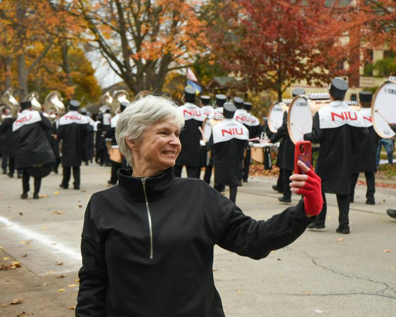 Phyllis Ludwig, of Texas in town for work, records video of the Northern Illinois University marching band as they march in the Pumpkin Parade to conclude the 62nd annual Sycamore Pumpkin Festival  on Sunday, Oct. 29, 2023.