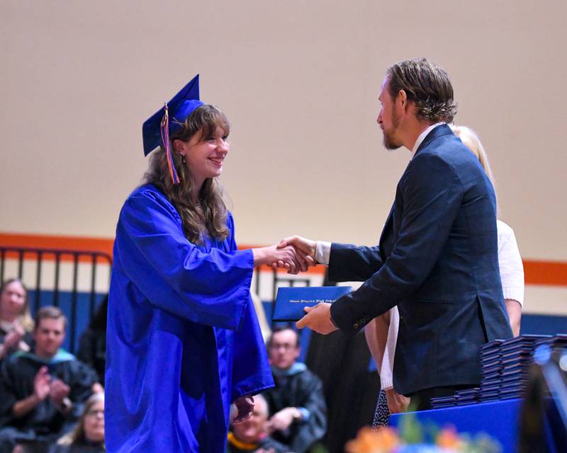 Genoa-Kingston senior Emma Hartzell shakes hands and receives her diploma during her graduation ceremony on Saturday, May 18, 2024, at Genoa-Kingston High School, 980 Park Ave., Genoa.