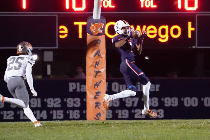 Oswego’s Jeremiah Cain (1) catches a pass for a touchdown against Minooka’s Caden Uphoff (25) during a football game at Oswego High School on Friday, October 18, 2024.