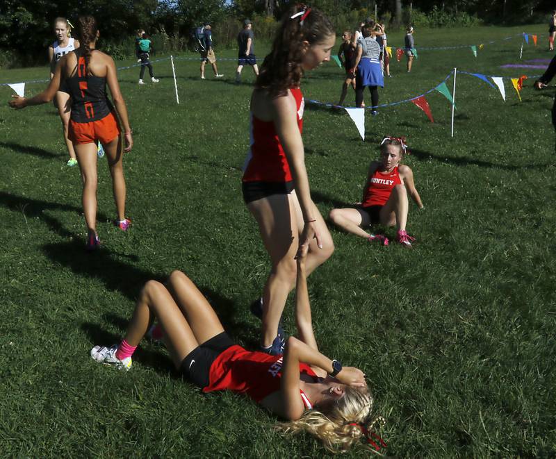 Huntley’s Morgan Sauber hits the hand of her teammate, Cori Kilvinger, after they finished the girls race of the McHenry County Cross Country Invite on Saturday, August 31, 2024, at McHenry Township Park in Johnsburg.