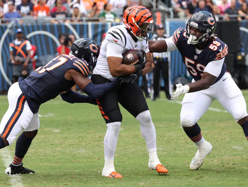 Chicago Bears linebacker Micah Baskerville (left) and defensive end Jamree Kromah bring down Cincinnati Bengals running back Noah Cain during their game Saturday, Aug. 17, 2024, at Soldier Field in Chicago.