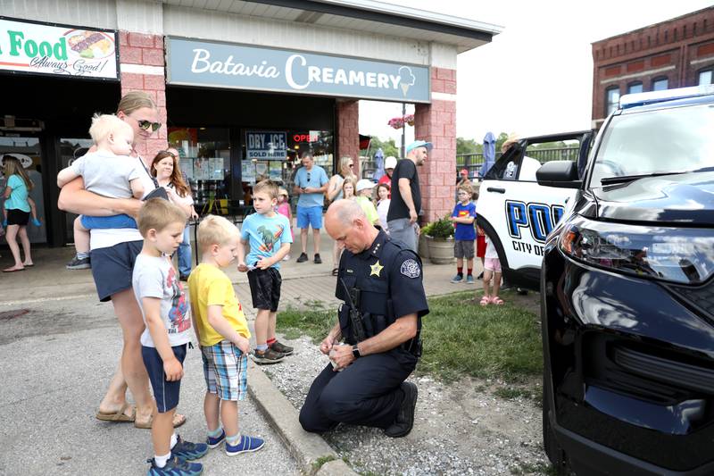 Batavia Police Chief Shawn Mazza hands out coupons for free ice cream scoops outside the Batavia Creamery on Thursday, June 6, 2024.