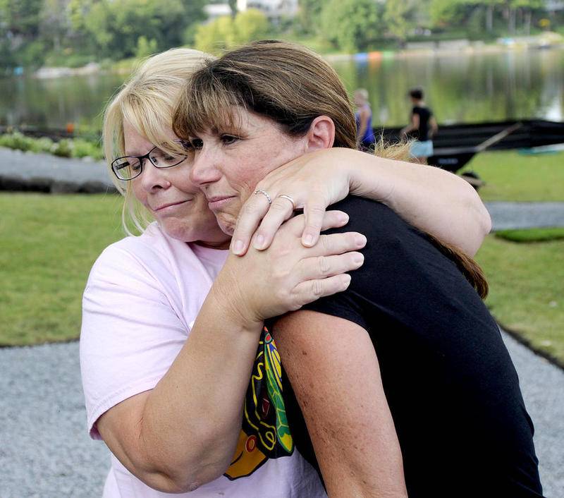 Volunteer Colleen Warchol (left) hugs Dawn Kincaid on Monday as Warchol works on a memorial garden in honor of Kincaid's son, Connor, who was killed in a car crash last year. The family will be hosting a fishing tournament in Connor's memory on Saturday.