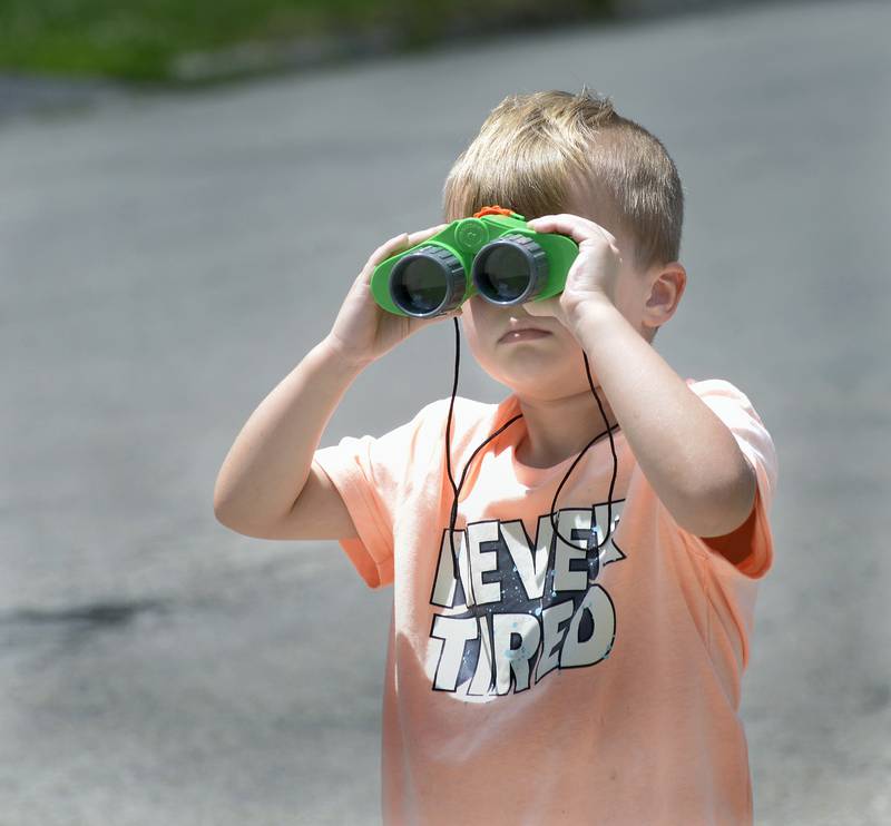 Grayson Bayer keeps a sharp eye out with his binoculars to see what is coming next down Broadway St in the Marseilles Fun Days Parade Sunday.