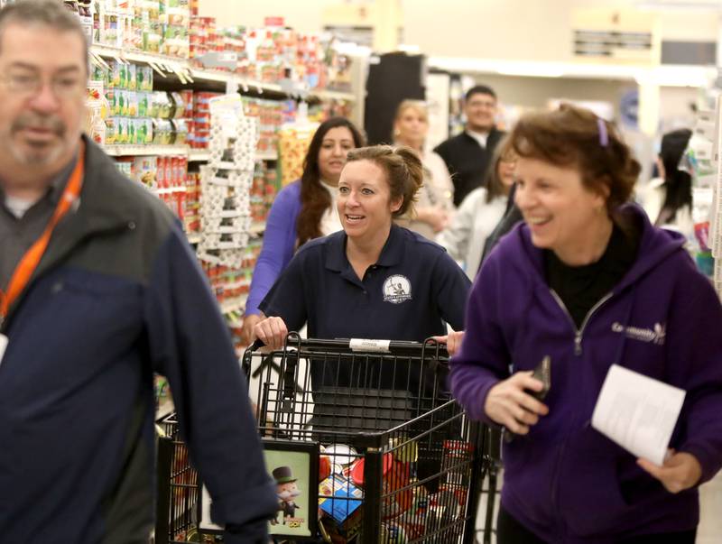 Kane County State’s Attorney Jamie Mosser races through the aisles for the Kane County Farm Bureau's 23rd Check Out Shopping Spree at the Jewel-Osco in Batavia on Monday, Feb. 26, 2024. Mosser collected food for Elgin's Community Crisis Center.​