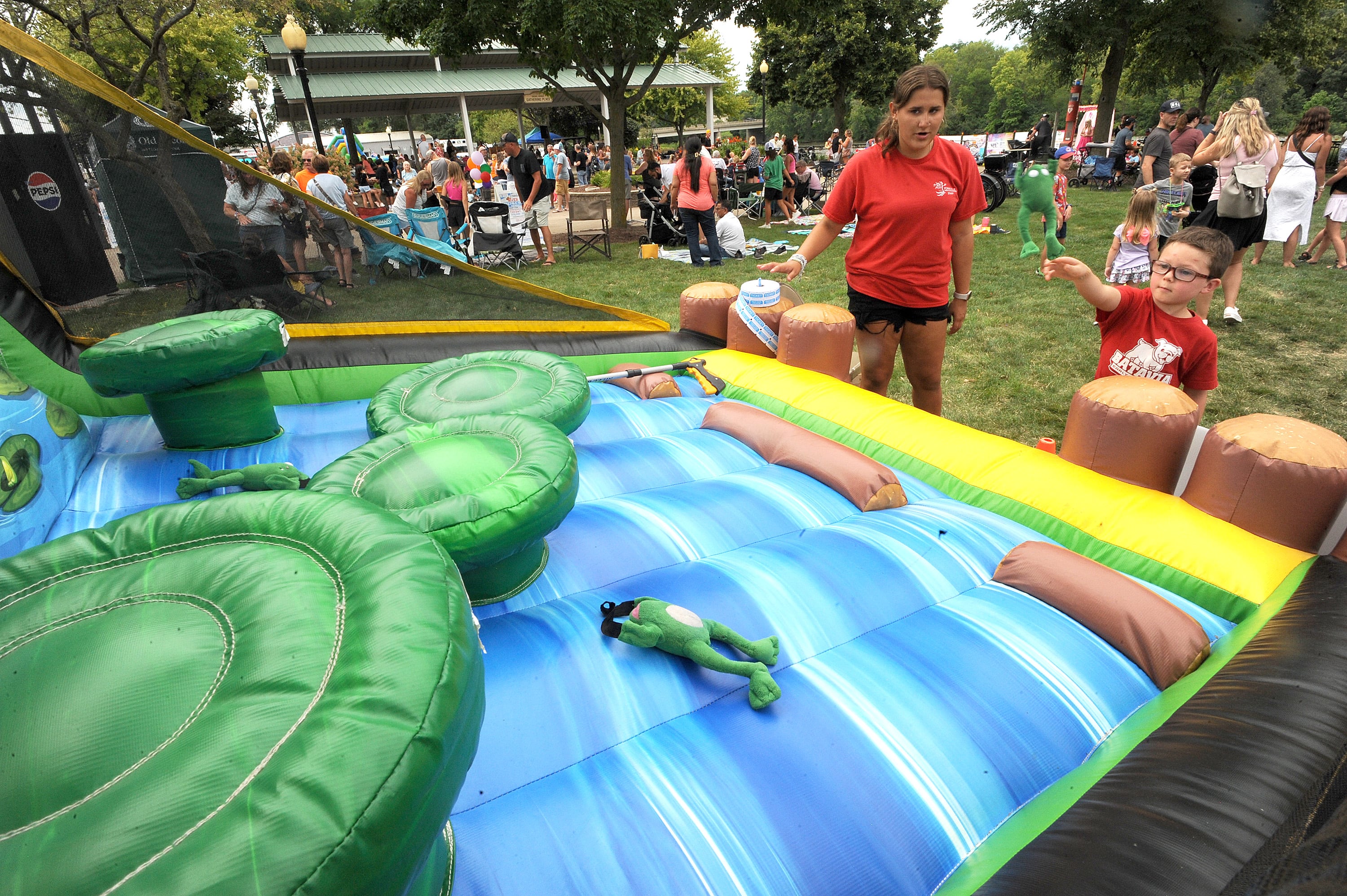 Five-year-old Logan Coyle of Aurora tosses a frog at the Happy Hoppers game during Riverfest on Hydraulic Avenue in Yorkville on Saturday, July 20, 2024.