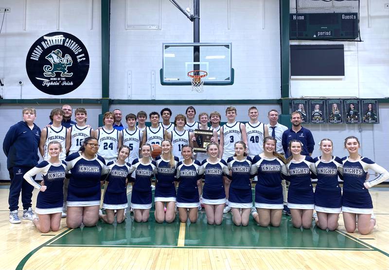 The Fieldcrest boys basketball team and cheer squad pose with the team's freshly won Class 2A Bishop McNamara Regional championship plaque Friday, Feb. 23, 2024, in Kankakee.