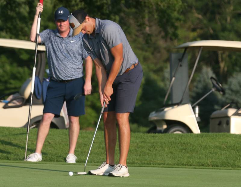 Baley Lehr sinks a putt on the 18th hole as Alex Blumenshine watches from behind during the Illinois Valley Men's Golf Championship on Sunday, July 28. 2024 at Mendota Golf Club.