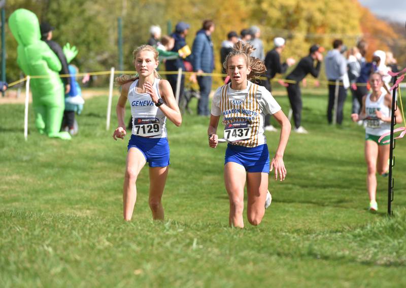 Geneva’s Sofia Borter, left, runs beside Wheaton North’s Emily Offutt at the Lake Park High School cross country sectional meet October 2023 in Medinah. Borter finished second overall while Offutt finished 18th.