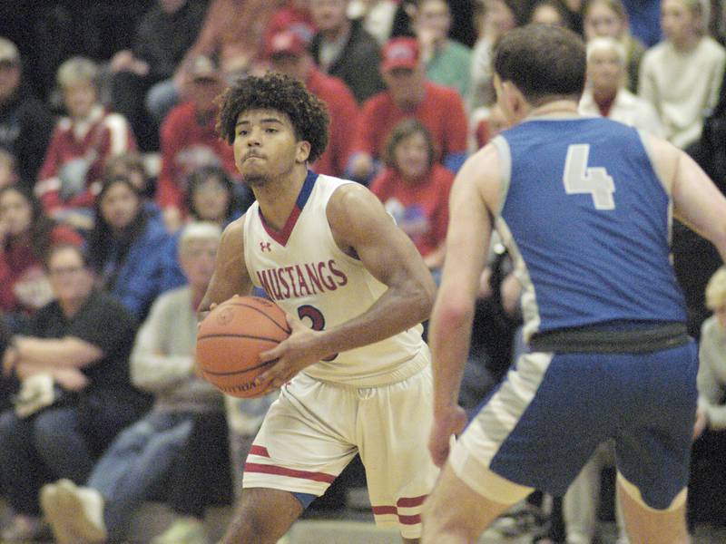 Morrison's Daeshaun McQueen passes the ball after being defended by Princeton's Korte Lawson during the Morrison vs Princeton class 2A basketball regional final at Prophetstown High School on Friday, Feb. 23 .