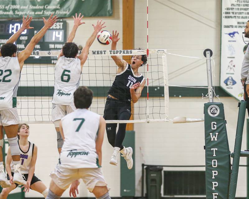 Downers Grove North's Aiden Akkawi (11) smashes the ball over the net for a kill during volleyball match between Downers Grove North at Glenbard West.  April 1, 2024.