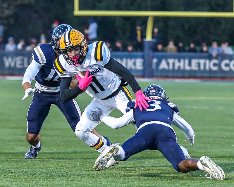 St Laurence's Connor Engstrom (11) makes a move on IC Catholic Prep's Kaleb Ellis (3) during Class 4A third round playoff football game between St Laurence at IC Catholic Prep.  Nov 11, 2023.