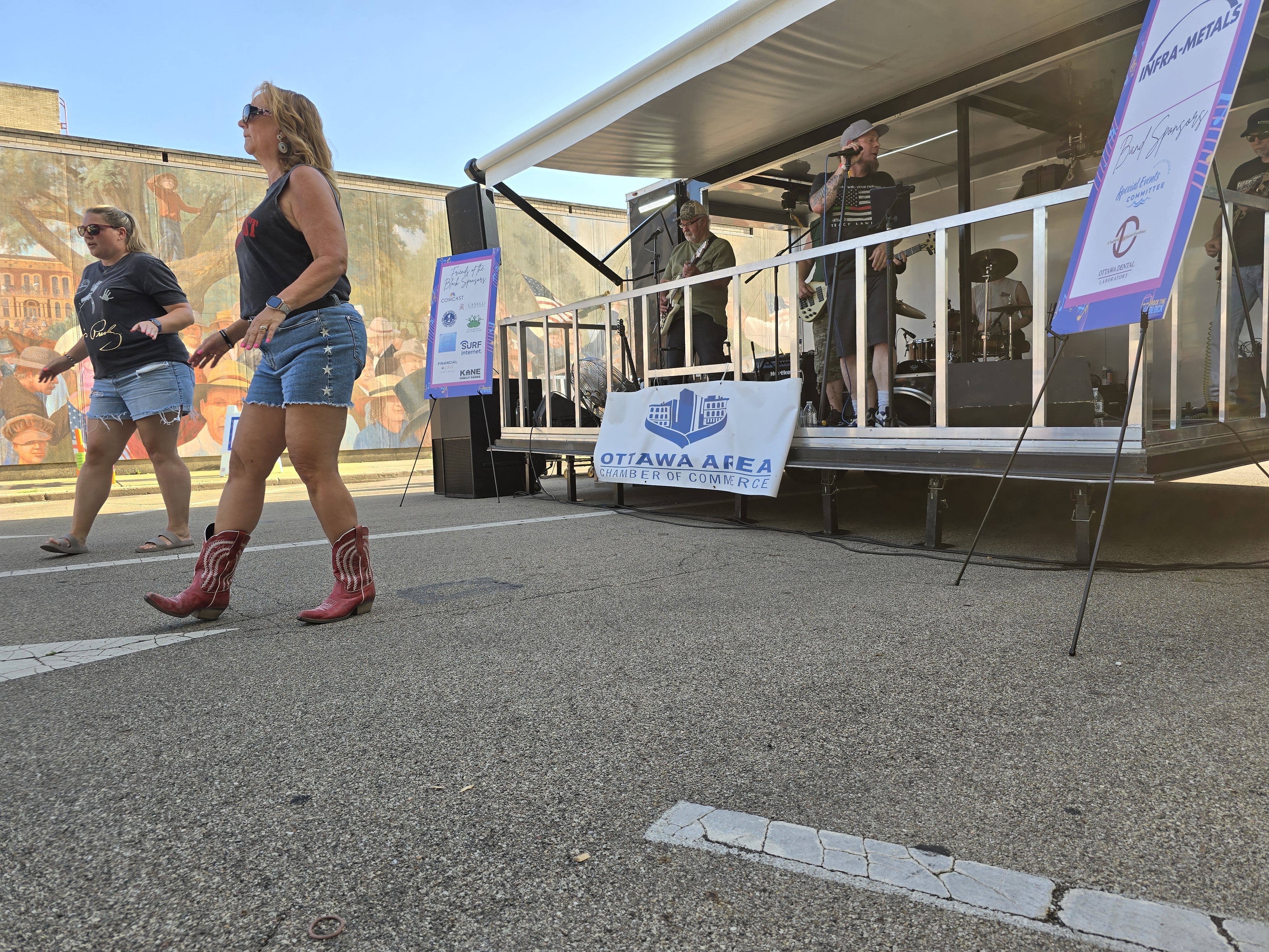 (From left) Jackie Konrad, of Chicago, and Michele Scholes, of South Wilmington, dance to performer Whiskeyfist on Wednesday, July 31, 2024, during the Rock the Block event on Jackson Street in Ottawa.