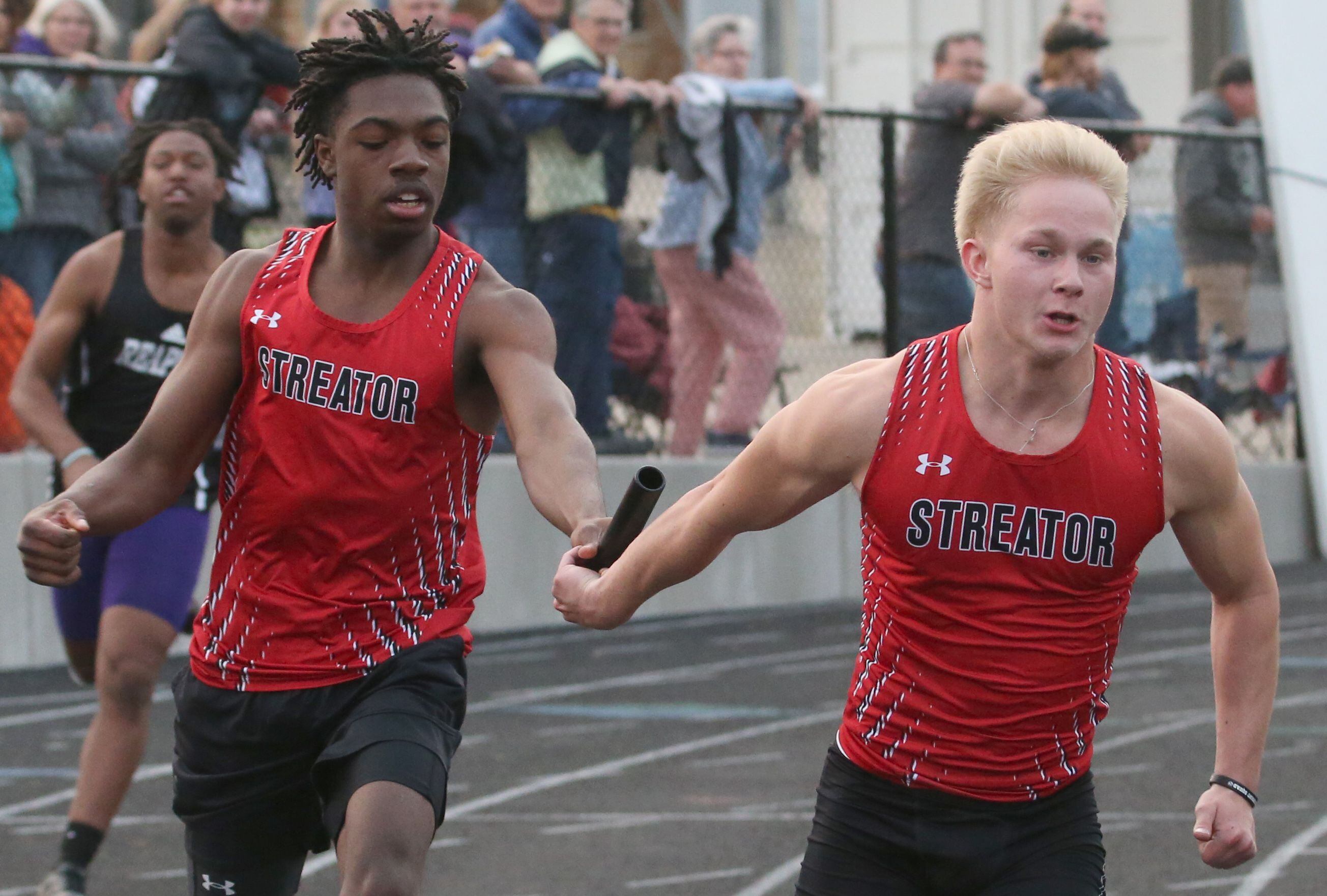 Streator's Collin Jeffries takes the baton from teammate Isaiah Brown in the 4x200-meter relay at the Class 2A track sectional meet on Wednesday, May 17, 2023 at Geneseo High School. 