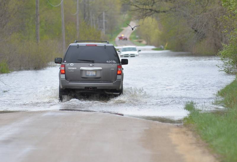 A SUV makes its way down a flooded access road along U.S. Route 84 near Albany on Sunday. The  Mississippi River continued to flood closing a section of Route 84 and prompting officials to close off flooded side roads. This vehicle was going to a residence along the road.