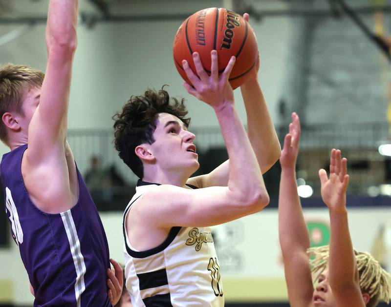 Sycamore's Jake Shipley goes up for a shot between two Rochelle defenders during their game Tuesday, Dec. 5, 2023, at Sycamore High School.