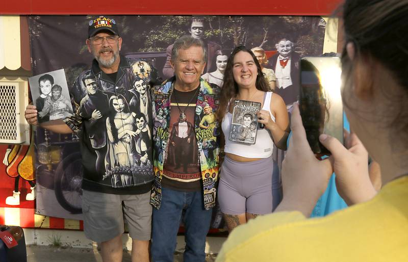 Bob Leisle and his daughter, Sarah, pose for a photograph with Butch Patrick, who played Eddie Munster on the 1960s show “The Munsters” after Patrick signed autographs, Wednesday,  Aug. 14, 2024, during an appearance at the McHenry Outdoor Theater.