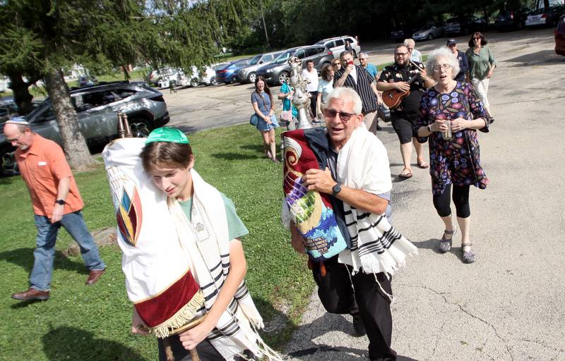 Congregation members march into their new location as the McHenry County Jewish Congregation moved items from their Ridgefield Road location to the Tree of Life Unitarian Church in McHenry on Sunday, August 18.