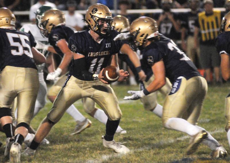 Marquette quarterback Anthony Couch hands off the ball to teammate Grant Dose in their game against Seneca at Gould Stadium on Friday, Sept. 13, 2024.