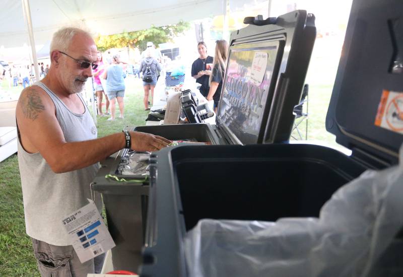 Steve Nodine of Lowpoint, checks out coolers for prizes during the Cops 4 Cancer fundraiser on Friday, July 26, 2024 at Cerri Memorial Park in Cedar Point. Cops 4 Cancer began in 2003. The group helps families in their fight against cancer, by providing financial assistance in a variety of ways.