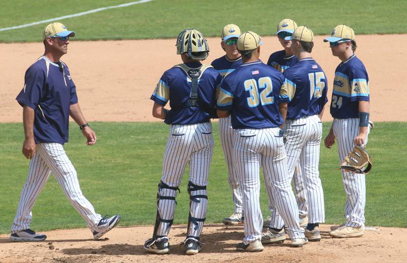 Marquette assistant coach Brad Waldron walks out to talk to his team on the mound during the Class 1A semifinal game on Friday, May 31, 2024 at Dozer Park in Peoria.