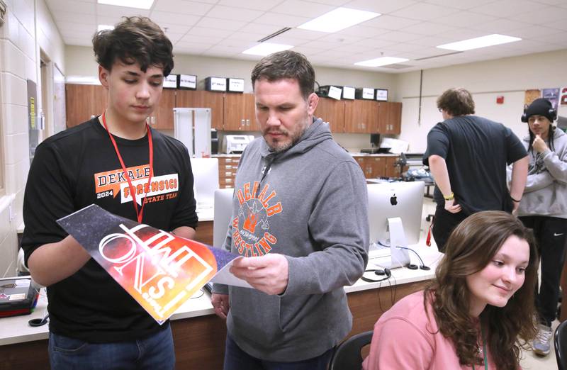 JD Oliva, (right) faculty advisor for BarbCast, helps a student during class Thursday, March 7, 2024, at DeKalb High School. Oliva works with students who are part of the BarbCast network that broadcasts live streaming video of sports and events at the school as well as putting together promotional materials.