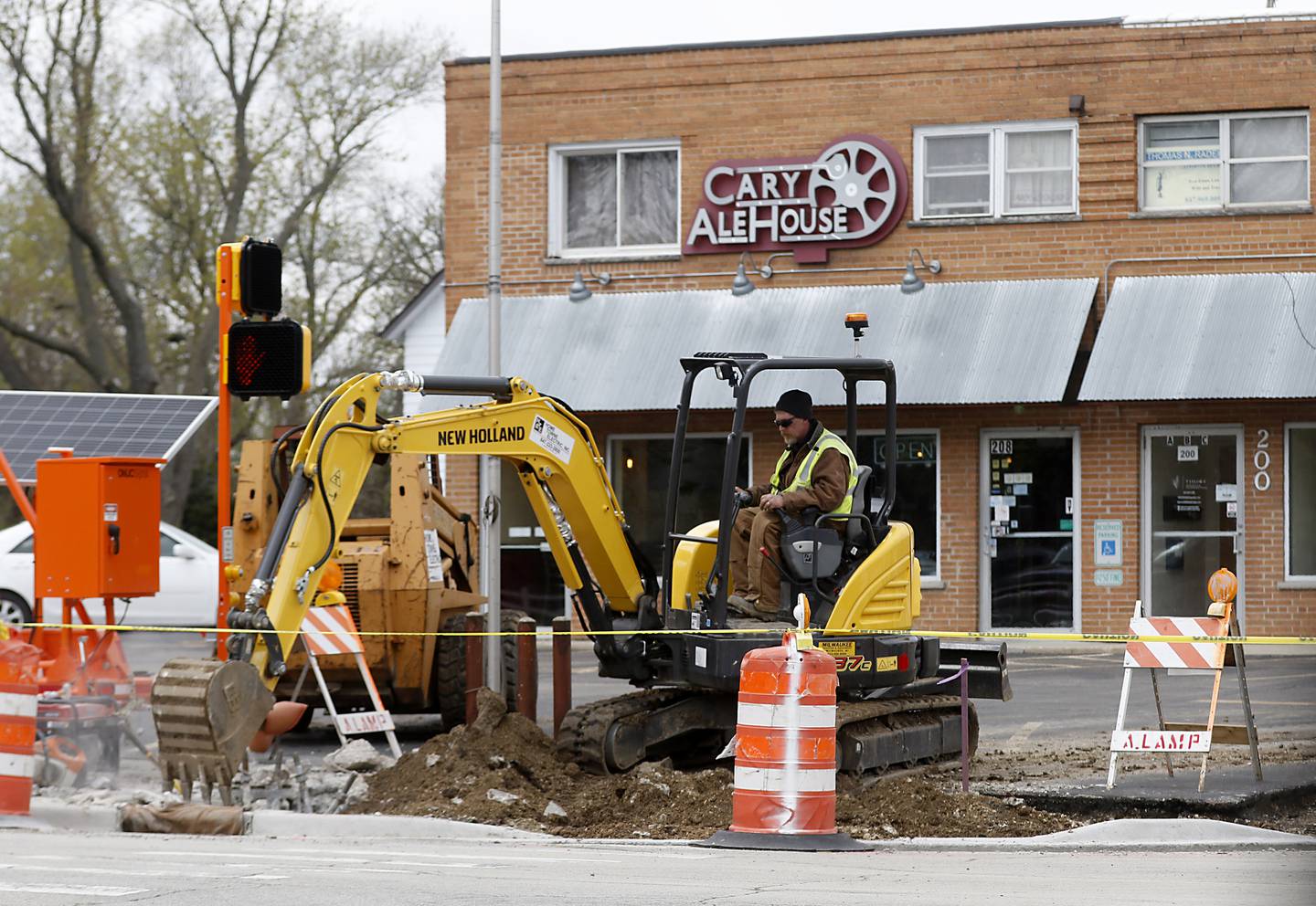 A construction worker digs up the sidewalk at the intersection of West Main Street and High Road in Cary on Tuesday, April 25, 2023. The village of Cary is considering a new tax increment financing district in its downtown corridor to help spur new development in the oldest part of its town.