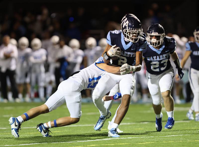 Nazareth’s Garrett Reese (2) is wrapped up by the St. Francis defense during the boys varsity football game on Friday, Oct. 20, 2023 in La Grange Park, IL.