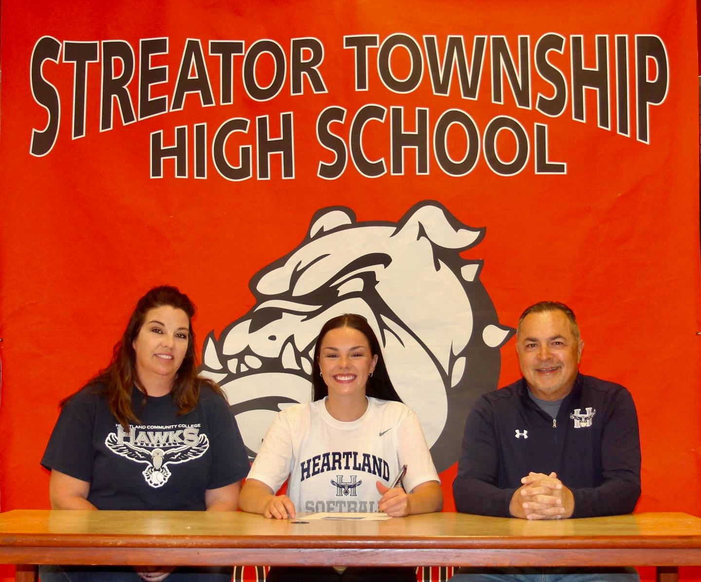 Recent Streator High School graduate Maci Byers has committed to continue her academic career at Heartland College and her softball career at the NJCAA level with the Hawks. Pictured here is Byers bookended by her parents, Amy and Chris Byers.