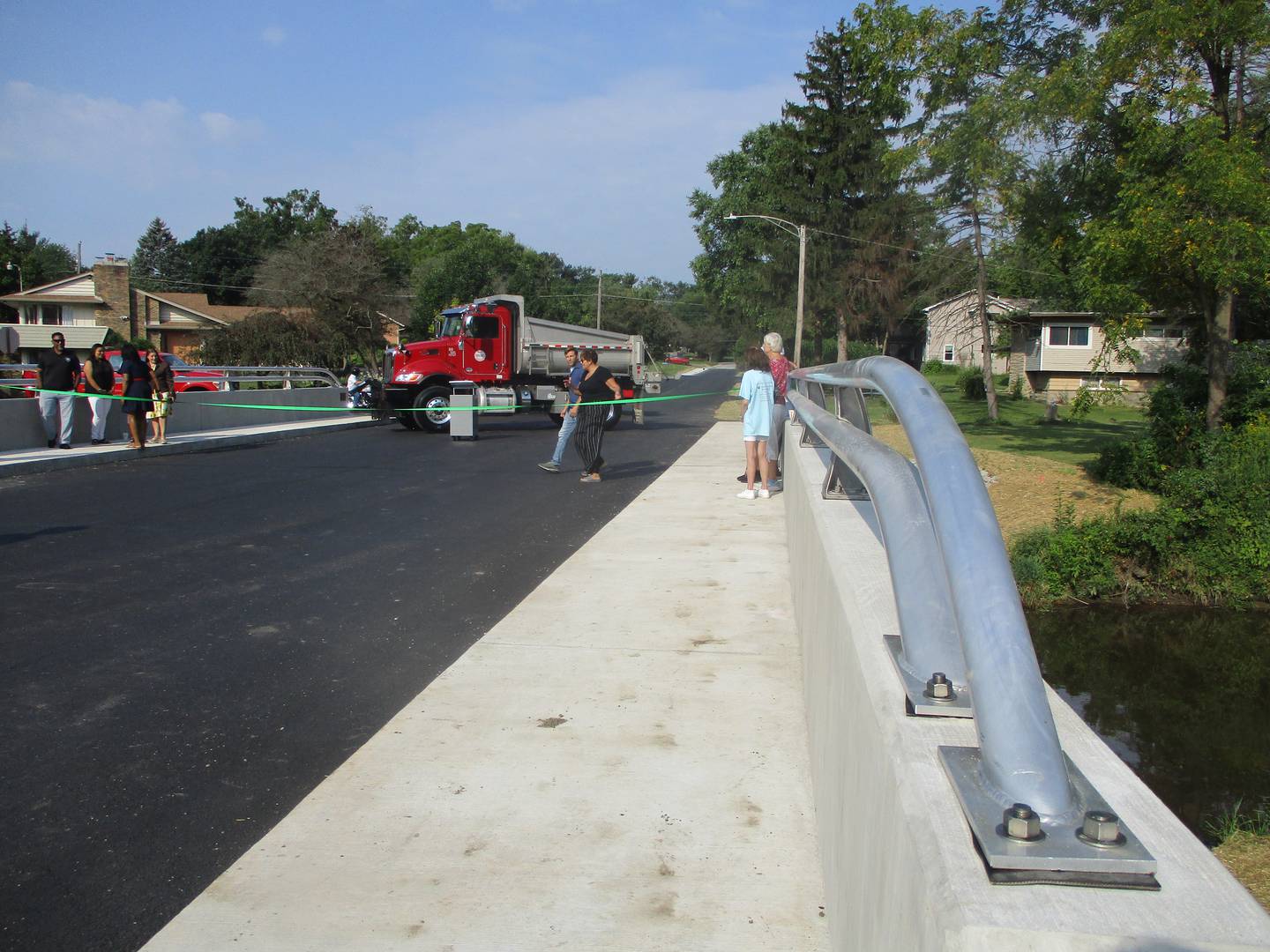 People gather for a ribbon-cutting ceremony on Monday for a new bridge that carries Sugar Creek Road over Sugar Creek in Joliet Township. Aug. 26, 2024