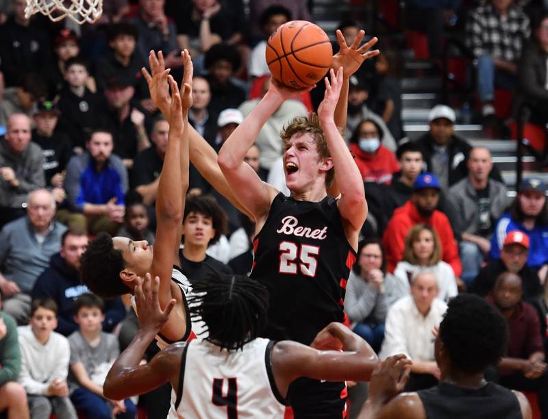 Benet's Gabe Sularski (25) shoots over Bolingbrook's Davion Thompson and Kevin Cathey (4) during a Class 4A East Aurora Sectional semifinal game on Feb. 27, 2024 at East Aurora High School in Aurora.