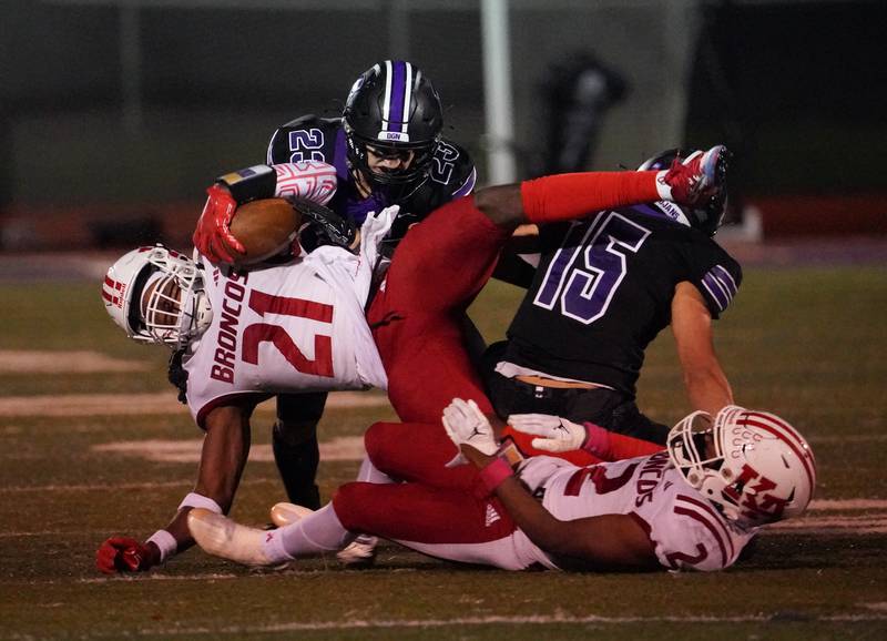 Downers Grove North's Weston Waughop (15) and Ethan Kist (23) tackle Kenwood's Patrick Clacks III (21) during a class 7A playoff football game at Downers Grove North on Friday, Oct. 27, 2023.