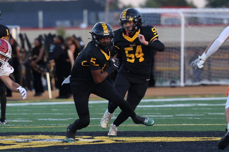 Joliet West’s Landon Mars cuts upfield with blocking help by Jaiden Morales against Morris on Friday, Sept. 6, 2024 in Joliet.