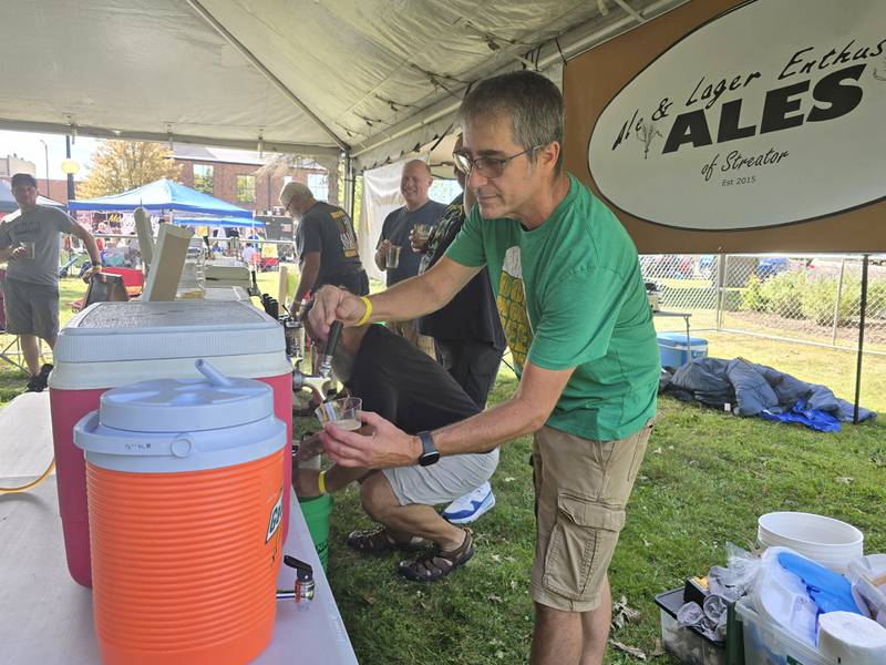 Travis Quick of ALES of Streator serves homemade beer Saturday, Sept. 14, 2024, during the homebrew tasting of the Pluto Festival at Streator's City Park.