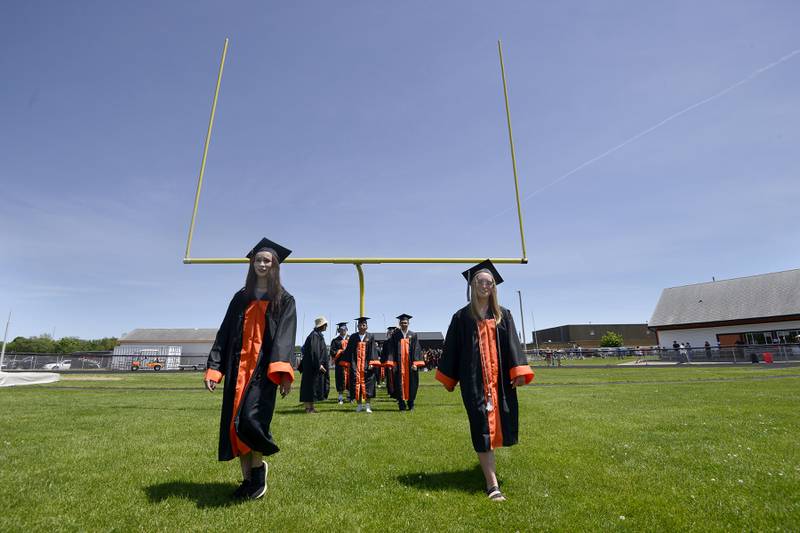 Natalie Atkinson and Jillian Ashley, walk on to the field to Pomp and Circumstance during Sandwich High School's graduation ceremony on the football field, Sunday, May 19, 2024.