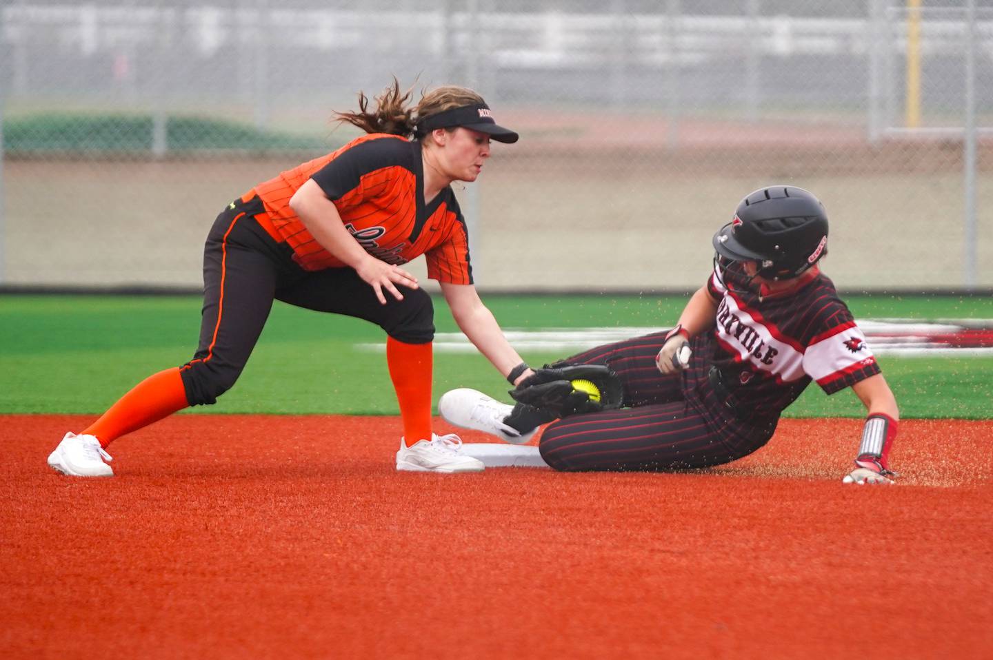 Yorkville's Sarah Carlson (right) beats the tag by Minooka's Karli McMillin (6) to steal second during a softball game at Yorkville High School on Thursday, April 11, 2024.