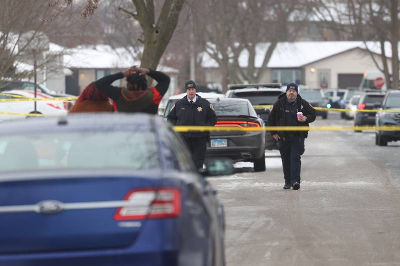 Joliet Police walk along West Acres Road at the scene were six people were found dead in two homes on Monday, Jan. 22nd in Joliet.