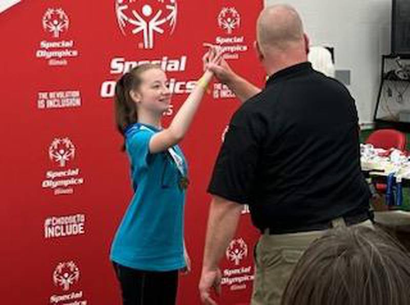 Cathrine Houzenga of Fulton receives her gold medal at the Special Olympics Illinois Summer Games.