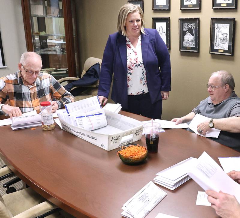 DeKalb County Clerk Tasha Sims visits with election judges Terry Heiland, (left) Steve Nemeth and Brian Frank (right) as they put vote-by-mail ballots in envelopes Wednesday, Feb. 22, 2023, in the DeKalb County Administration Building in Sycamore.