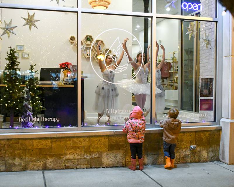 3-year-old twins Bonnie Cessna and Landon Cessna, of Maple Park, watch dancers during the Sycamore Chamber of Commerce's annual Moonlight Magic event held in downtown Sycamore on Friday, Nov. 17, 2023.