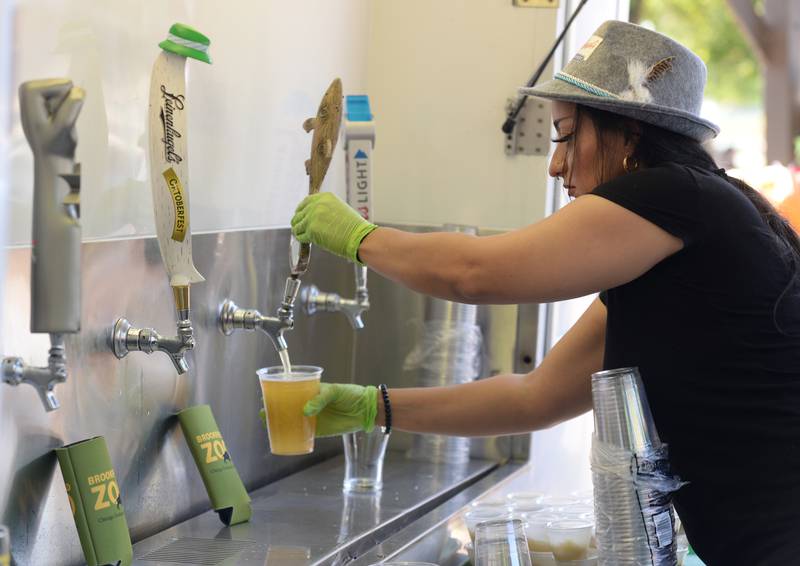 Brookfield Zoo staff members including Elizabeth Garza pours beers for people attending the Octoberfest held Saturday, Sept. 23, 2023.