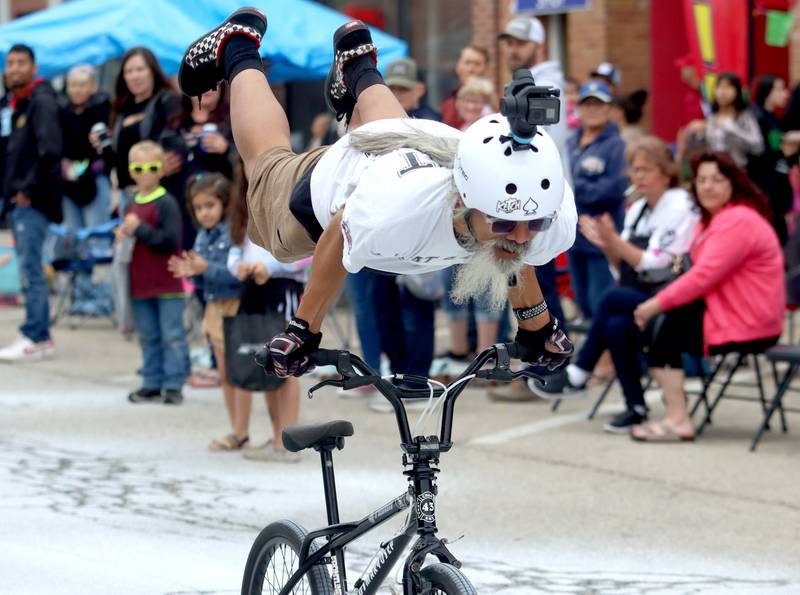 A stunt rider from Flat 43 BMX surfs down Ayer Street during the Harvard Milk Days parade Saturday, June 4, 2022, in Harvard.