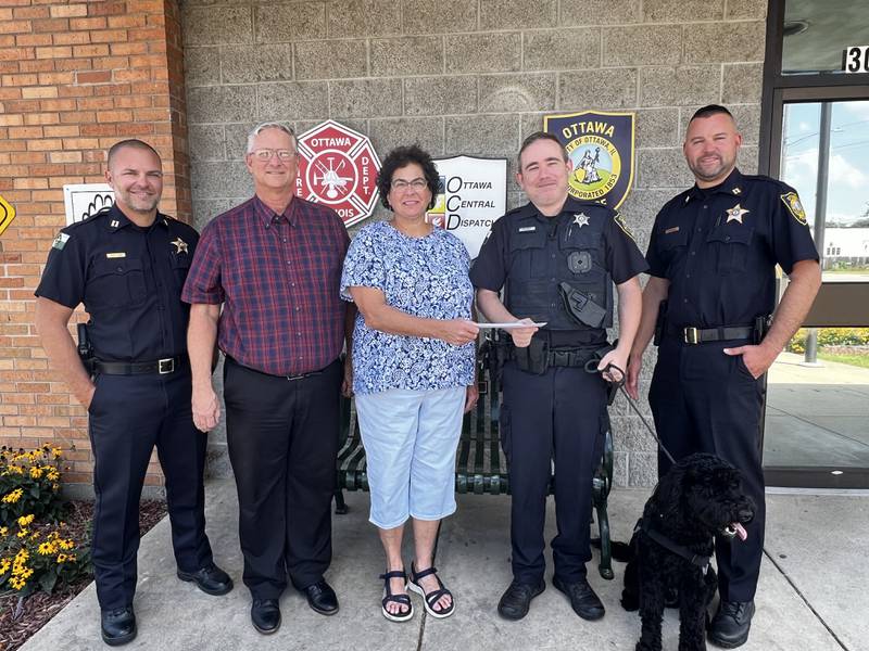 Ottawa Sunrise Rotary President Julie Fisher presents a donation check to Ottawa Police Community Officer Tyler Brewer. Pictured are (from left) Ottawa Police Capt. Mike Cheatham, Ottawa Noon Rotary President Dave Noble, Fisher, Brewer, Rookie and Ottawa Police Capt. Kyle Booras.