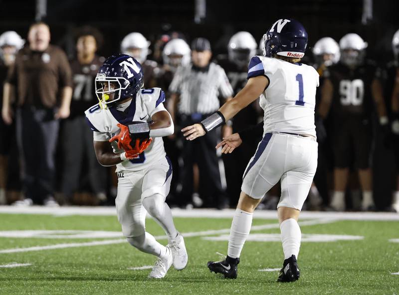 Nazareth's Edward McClain Jr. (0) takes a handoff from Logan Malachuk (1) during the varsity football game between Nazareth Academy and Mt. Carmel high school on Friday, Sep. 13, 2024 in Chicago.