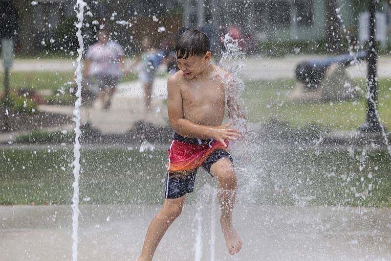 Eli Olalde, 8, of Fulton splashes through the fountain Thursday, June 20, 2024 at Grandon Park in Sterling. It was another great day to find a cool spot or take a dip as temps again stayed in the 90’s.