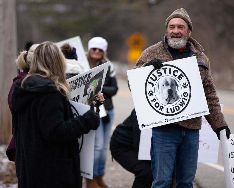 Joe Petit, whose dog Ludwig was shot to death by a neighbor, holds up signs during the Justice for Ludwig protest outside the Little Home Church by the Wayside in Wayne on Saturday, Jan. 7, 2023. Inside the church a town hall meeting took place to discuss an architectural review of the village hall and police department.